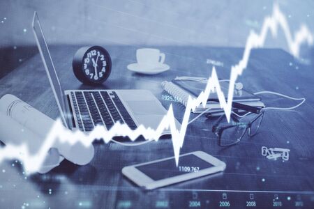Stock market graph on background with desk and personal computer. Double exposure. Concept of...