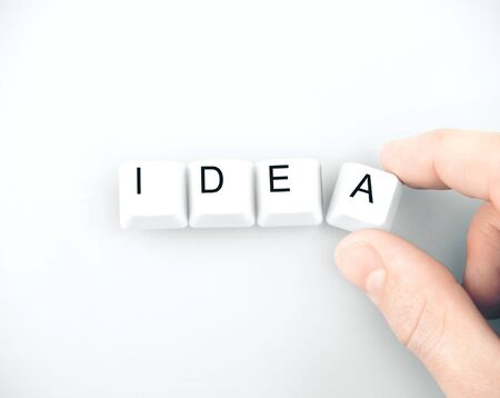 Businessman hand folds the word idea on white background, Business idea concept.  Close up