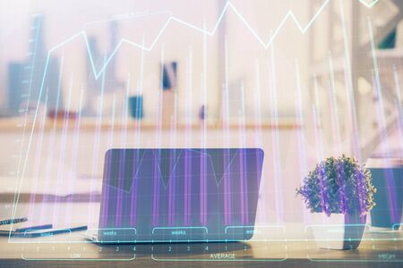 Stock market graph on background with desk and personal computer. Multi exposure. Concept of financial analysis.の写真素材