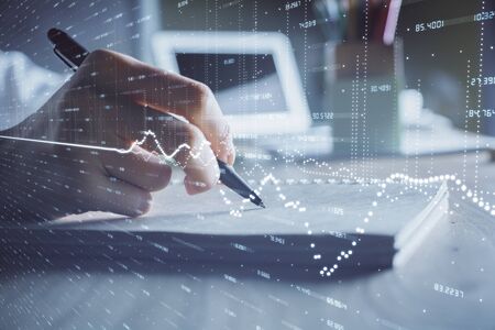 Financial charts displayed on woman's hand taking notes background. Concept of research. Double exposureの写真素材