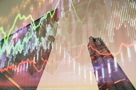 Forex chart on cityscape with tall buildings background multi exposure. Financial research concept.の写真素材