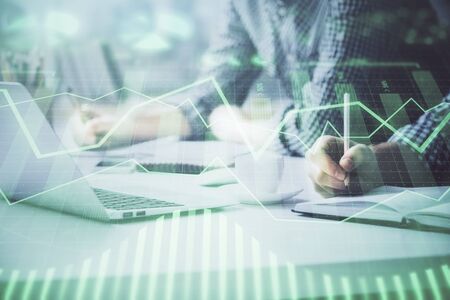 Multi exposure of forex chart with man working on computer on background. Concept of market...