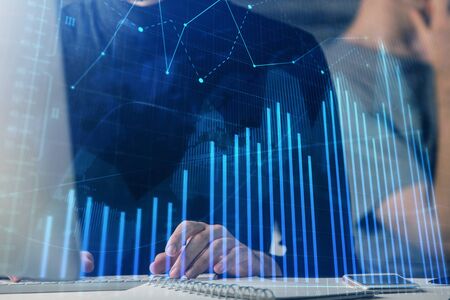 Forex graph with businessman typing on computer in office on background. Concept of analysis. Double...
