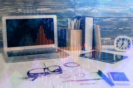 Double exposure of graph and financial info and work space with computer background. Concept of international online trading.の写真素材