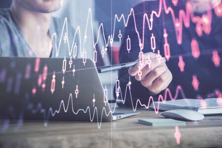 Forex graph with businessman typing on computer in office on background. Concept of analysis. Double exposure.の写真素材