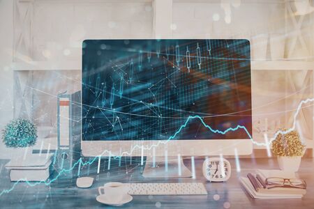 Forex graph hologram on table with computer background. Double exposure. Concept of financial markets.の写真素材