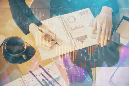 Double exposure of hands making notes with forex chart huds. Stock market concept.の写真素材