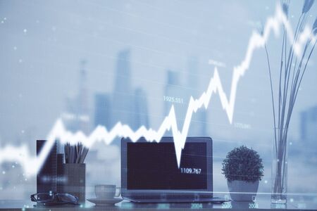 Forex graph hologram on table with computer background. Multi exposure. Concept of financial...