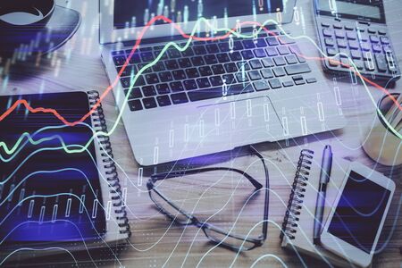 Forex market graph hologram and personal computer on background. Multi exposure. Concept of...