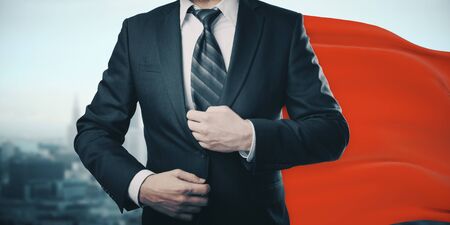 Businessman with red superhero cape on city backgroundの写真素材