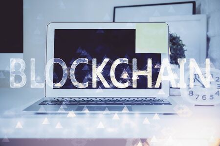 Multi exposure of blockchain theme hologram and table with computer background. Concept of bitcoin crypto currency.の写真素材