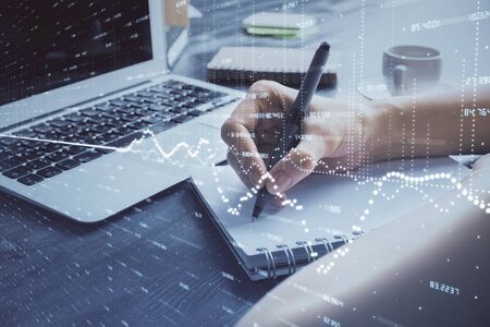 Forex chart displayed on woman's hand taking notes background. Concept of research. Multi exposureの写真素材