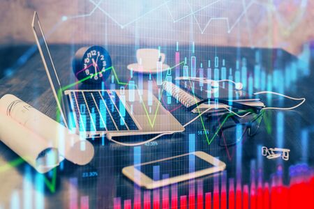 Forex market graph hologram and personal computer on background. Double exposure. Concept of investment.の写真素材
