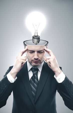 Young thinking businessman with lamp in head.  Business success concept.の写真素材