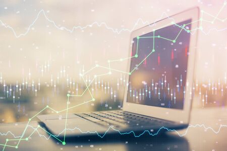 Financial chart drawing and table with computer on background. Double exposure. Concept of international markets.の写真素材