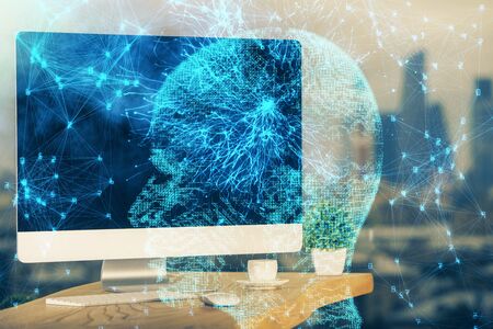 Double exposure of table with computer and brain hologram. Data innovation concept.
