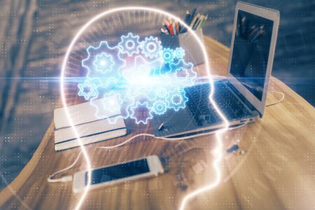 Double exposure of table with computer and brain hologram. Data innovation concept.