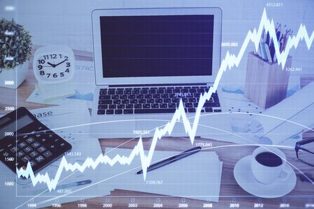 Stock market chart hologram drawn on personal computer background. Double exposure. Concept of...