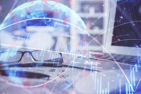 Financial chart hologram with glasses on the table background. Concept of business. Double exposure.の写真素材