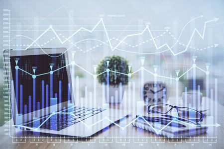 Stock market chart hologram drawn on personal computer background. Double exposure. Concept of investment.の写真素材