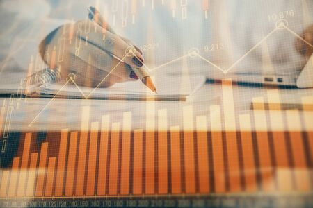 Double exposure of womans hands making notes with forex graph hologram. Concept technical analysis.の写真素材