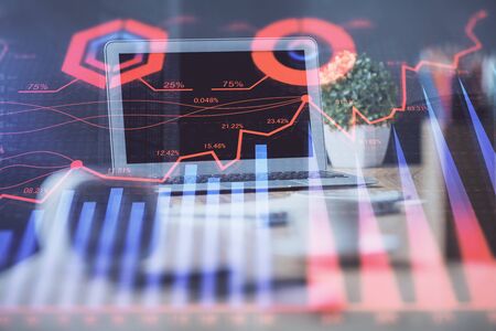 Stock market graph on background with desk and personal computer. Double exposure. Concept of financial analysis.の写真素材