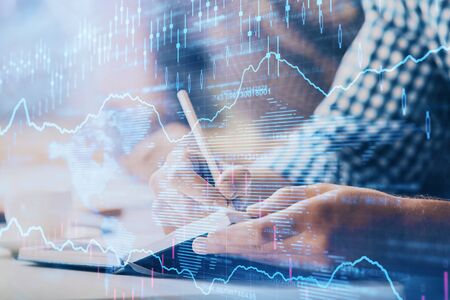 Multi exposure of two men planing investment with stock market forex chart.