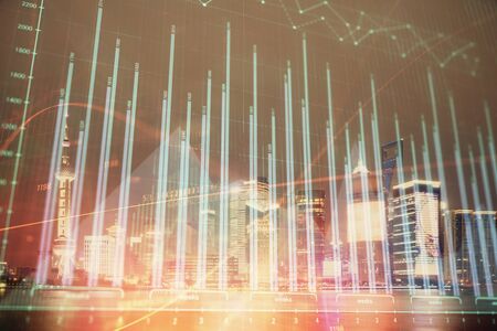 Financial graph on night city scape with tall buildings background double exposure. Analysis concept.の写真素材