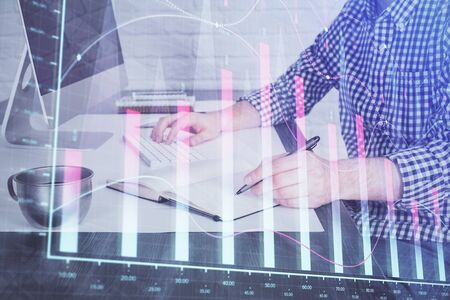 Double exposure of stock market chart with man working on computer on background. Concept of financial analysis.の写真素材