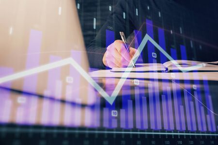 Double exposure of businessman with laptop and stock market forex chart.の写真素材