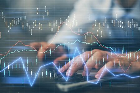 Forex graph with businessman working on computer in office on background. Concept of hardworking....