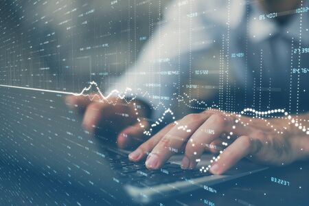 Forex graph with businessman working on computer in office on background. Concept of hardworking....