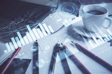Stock market chart hologram drawn on personal computer background. Double exposure. Concept of investment.の写真素材