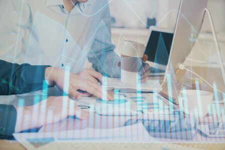Multi exposure of chart with man typing on computer in office on background. Concept of hard work.