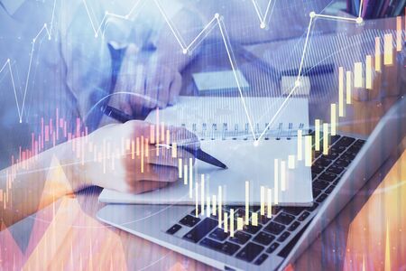 Financial charts displayed on woman's hand taking notes background. Concept of research. Double...