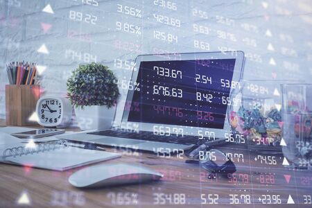 Financial market graph hologram and personal computer on background. Double exposure. Concept of forex.の写真素材