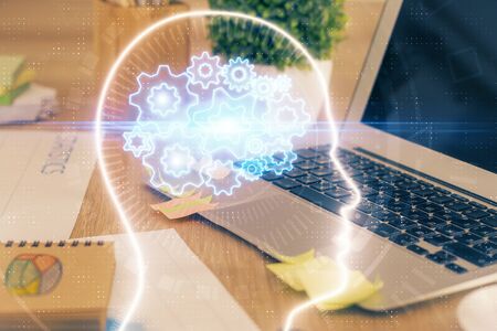 Double exposure of table with computer and brain hologram. Data innovation concept.