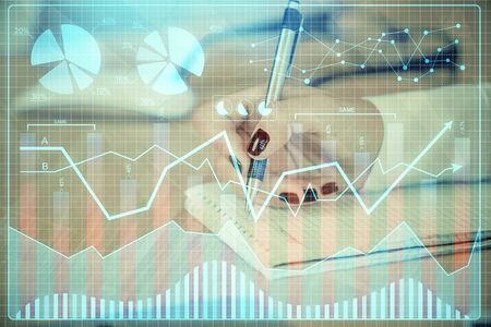 Multi exposure of hands making notes with forex chart huds. Stock market concept.の写真素材
