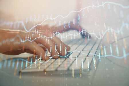 Forex graph with businessman working on computer in office on background. Concept of hardworking....