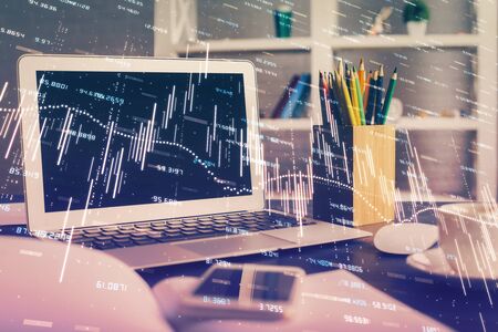 Financial graph colorful drawing and table with computer on background. Double exposure. Concept of international markets.の写真素材