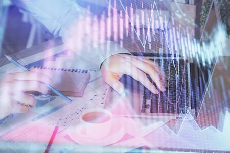 Forex graph with businessman working on computer in office on background. Concept of hardworking. Multi exposure.の写真素材