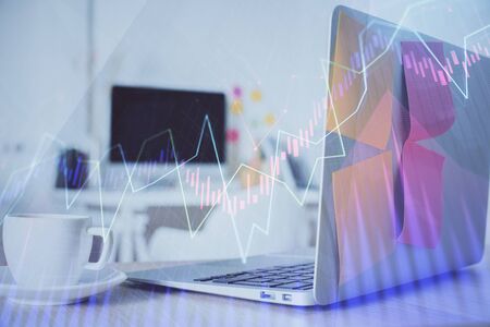 Stock market graph on background with desk and personal computer. Double exposure. Concept of financial analysis.の写真素材