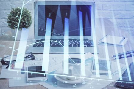 Forex Chart hologram on table with computer background. Multi exposure. Concept of financial markets.の写真素材