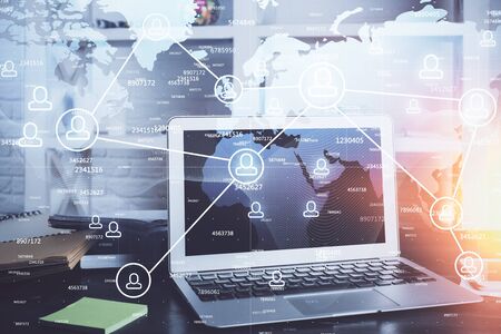 Computer on desktop with social network theme icon. Multi exposure. Concept of international connections.の写真素材