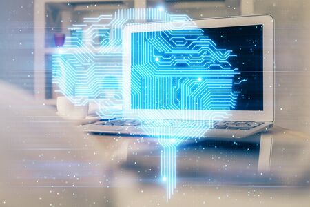 Double exposure of table with computer and brain hologram. Data innovation concept.