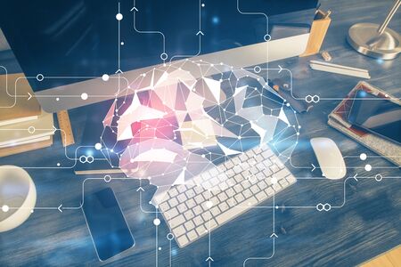 Double exposure of table with computer and brain hologram. Data innovation concept.