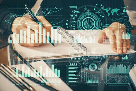 Forex chart hologram on hand taking notes background. Concept of analysis. Multi exposureの写真素材