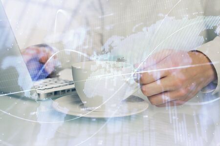 Double exposure of graph with man typing on computer in office on background. Concept of hard work.の写真素材