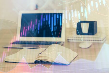 Stock market graph on background with desk and personal computer. Double exposure. Concept of financial analysis.の写真素材