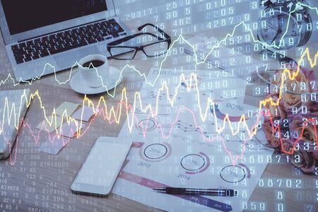 Financial chart drawing and table with computer on background. Double exposure. Concept of international markets.の写真素材